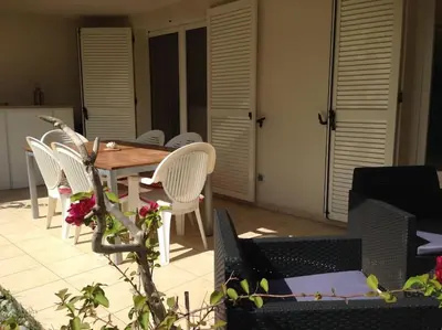 a wooden table and chairs on a patio at Appartement charmant en Corse avec terrasse au calme in Santa-Lucia-di-Moriani