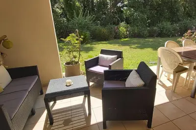 a patio with chairs and tables and a table and chairs at Appartement charmant en Corse avec terrasse au calme in Santa-Lucia-di-Moriani