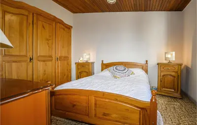 a bedroom with a wooden bed and wooden cabinets at 2 Bedroom Cozy Home In San Nicolao in San-Nicolao