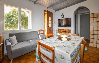 a living room with a table and a couch at 2 Bedroom Cozy Home In San Nicolao in San-Nicolao