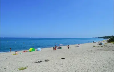 a group of people on a beach near the water at 2 Bedroom Cozy Home In San Nicolao in San-Nicolao
