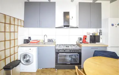 a kitchen with a stove and a washing machine at 2 Bedroom Cozy Home In San Nicolao in San-Nicolao