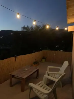 two chairs and a table on a patio at night at Appartement 35m2 climatisé a 10 min d’Ajaccio in Alata