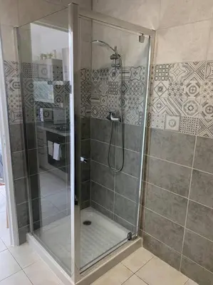 a shower with a glass door in a bathroom at Appartement 35m2 climatisé a 10 min d’Ajaccio in Alata
