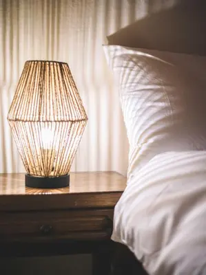 a lamp sitting on a table next to a bed at Eco lodge Carbonaccio in Chiatra