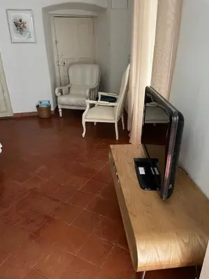 a living room with a flat screen tv and chairs at Maison de caractère rénovée Coggia in Coggia