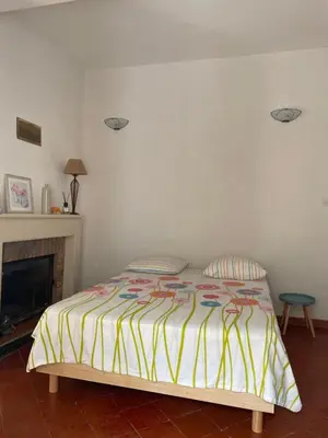 a bedroom with a bed with a yellow and white blanket at Maison de caractère rénovée Coggia in Coggia