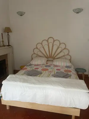 a bed with a large headboard in a room at Maison de caractère rénovée Coggia in Coggia
