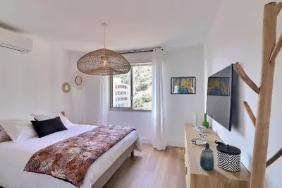 a bedroom with a bed and a desk and a window at Nouveau ! T2 neuf avec vue imprenable mer in Ajaccio