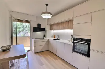a kitchen with white cabinets and a large window at Nouveau ! T2 neuf avec vue imprenable mer in Ajaccio