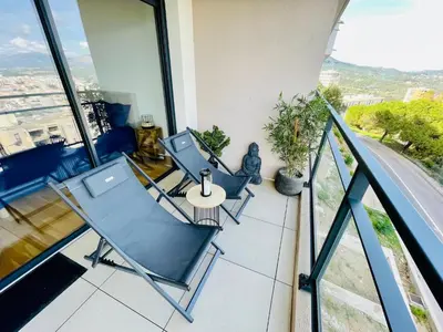 a balcony with chairs and a table on a building at Ajaccio T2 grand standing neuf vue mer centre-ville & plages in Ajaccio