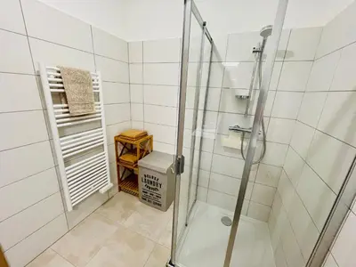 a shower with a glass door in a bathroom at Ajaccio T2 grand standing neuf vue mer centre-ville & plages in Ajaccio