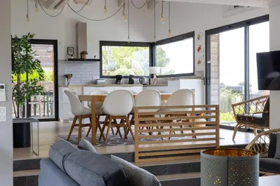 a kitchen and living room with a table and chairs at Villa ARIA, piscine, vue mer 120 m2 tout confort - 4 personnes in Pietrosella