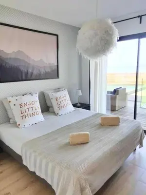 a bedroom with a large white bed with two pillows at Villa ARIA, piscine, vue mer 120 m2 tout confort - 4 personnes in Pietrosella