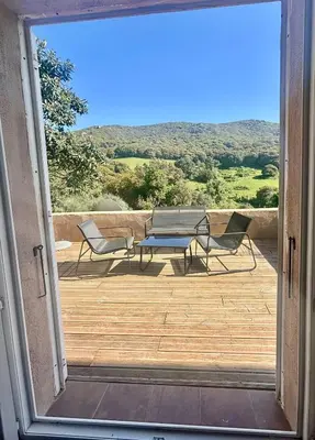 an open door to a patio with a table and chairs at Campana in Sartène