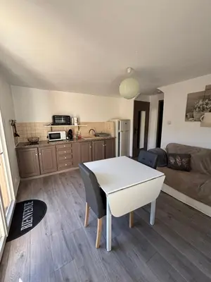 a living room with a table and a kitchen at Campana in Sartène