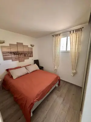a bedroom with a bed with orange sheets and a window at Campana in Sartène