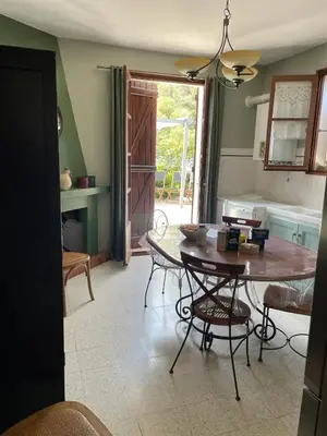 a kitchen with a table and chairs in a room at Maison accueillante avec vue sur la mer à Grosseto-Prugna in Grosseto-Prugna