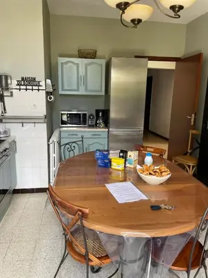 a kitchen with a wooden table and a refrigerator at Maison accueillante avec vue sur la mer à Grosseto-Prugna in Grosseto-Prugna