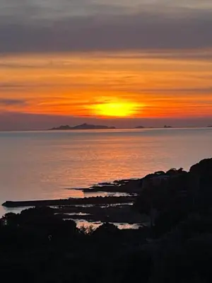 a sunset over the ocean with the sun setting at Maison accueillante avec vue sur la mer à Grosseto-Prugna in Grosseto-Prugna