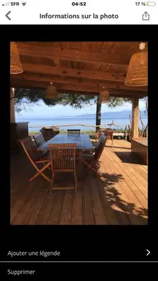 a picture of a table and chairs on a deck at Villa Terra Casanova pieds dans l'eau à 20 mn d Ajaccio in Villanova
