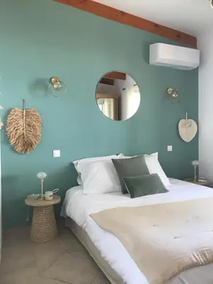a blue bedroom with a bed and a mirror at Villa Terra Casanova pieds dans l'eau à 20 mn d Ajaccio in Villanova