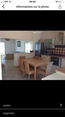 a kitchen and dining room with a wooden table and chairs at Villa Terra Casanova pieds dans l'eau à 20 mn d Ajaccio in Villanova