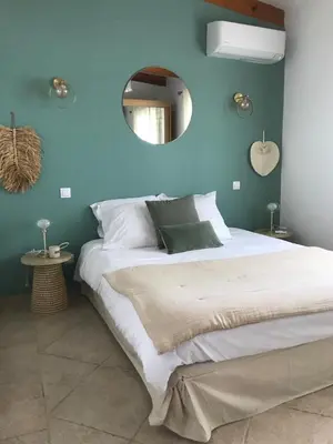 a blue bedroom with a large bed and a mirror at Villa Terra Casanova pieds dans l'eau à 20 mn d Ajaccio in Villanova