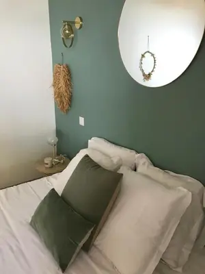 a bedroom with a bed with a mirror on the wall at Villa Terra Casanova pieds dans l'eau à 20 mn d Ajaccio in Villanova
