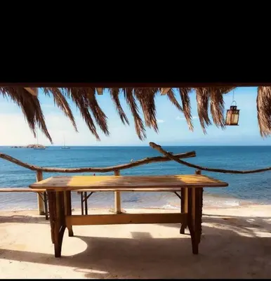 a picnic table on the beach with a view of the ocean at Villa Terra Casanova pieds dans l'eau à 20 mn d Ajaccio in Villanova
