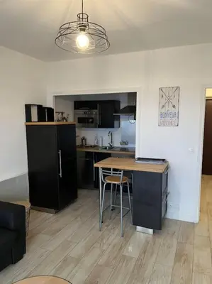 a kitchen with a table and a counter in a room at SUPERBE APPARTEMENT FACE AUX ILES SANGUINAIRES in Ajaccio