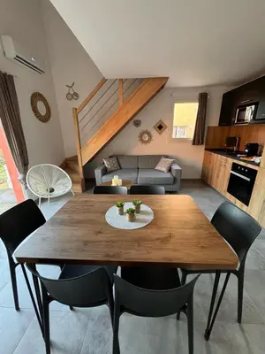 a patio with a table and chairs on a porch at Résidence hôtelière les hameaux de saint cyprien appartement 2 chambres in Lecci