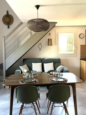 a living room with a table and chairs and a couch at Résidence hôtelière les hameaux de saint cyprien appartement 2 chambres in Lecci