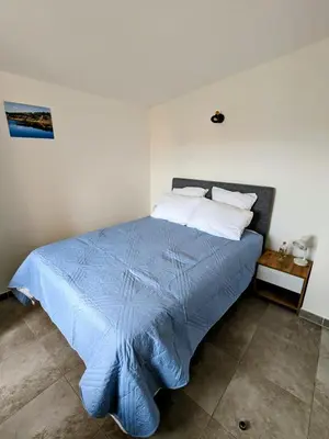 a bedroom with a bed and a table and a chair at Résidence hôtelière les hameaux de saint cyprien appartement 2 chambres in Lecci