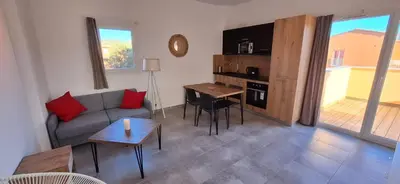 a living room with a couch and a table at Résidence hôtelière les hameaux de saint cyprien appartement 35 M2 1 chambre in Lecci