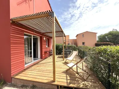 a deck with two chairs on a house at Résidence hôtelière les hameaux de saint cyprien appartement 35 M2 1 chambre in Lecci