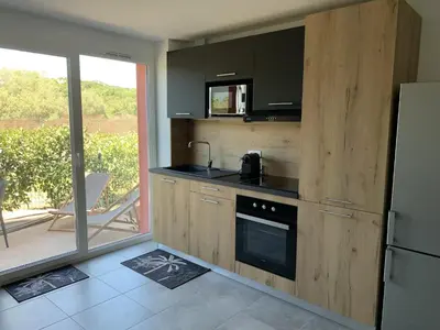 a kitchen with a stove and a refrigerator at Résidence hôtelière les hameaux de saint cyprien appartement 35 M2 1 chambre in Lecci