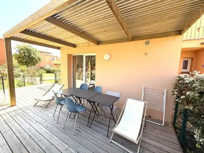 a patio with a table and chairs on a deck at Résidence hôtelière les hameaux de saint cyprien appartement 35 M2 1 chambre in Lecci