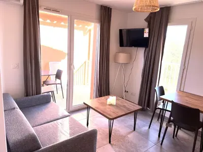 a living room with a couch and a table at Résidence hôtelière les hameaux de saint cyprien 25 M2 in Lecci