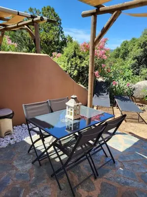 a surfboard sitting on the ground in front of a house at MINI VILLA A 5MIN À PIEDS DE LA PLAGE SANTA GIULIA in Porto-Vecchio