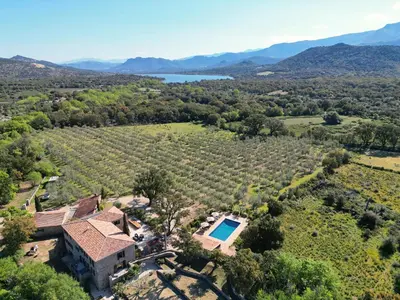 an outdoor swimming pool with chairs and umbrellas at Domaine du Reginu in Santa-Reparata-di-Balagna
