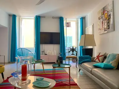 a living room with blue curtains and a couch at Spacieux et confortable appartement T3 au centre ville d Ajaccio in Ajaccio