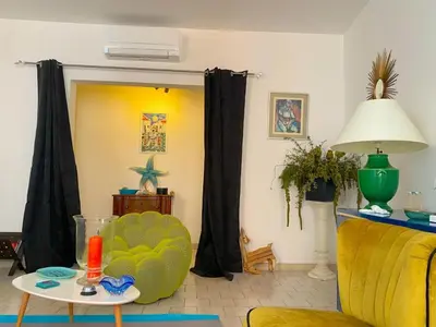 a living room with a yellow chair and a table at Spacieux et confortable appartement T3 au centre ville d Ajaccio in Ajaccio