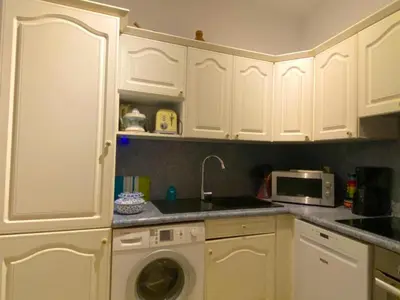 a kitchen with white cabinets and a washing machine at Spacieux et confortable appartement T3 au centre ville d Ajaccio in Ajaccio