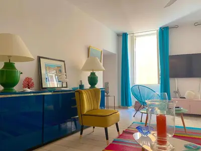 a living room with a yellow chair and a table at Spacieux et confortable appartement T3 au centre ville d Ajaccio in Ajaccio