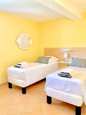 two beds in a room with yellow walls at Villa U Tramontu in Granace