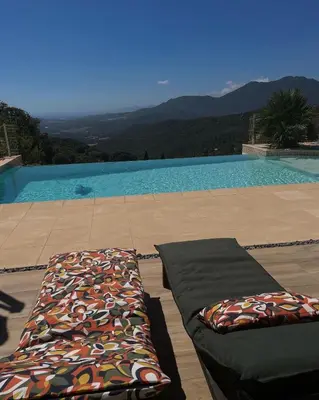 a pair of pillows on a patio next to a swimming pool at Villa U Tramontu in Granace