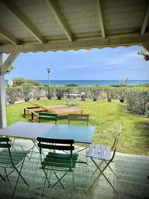 a table and chairs on a patio with a view of a field at La Casetta Prunete in Cervione
