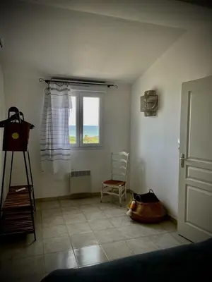 a living room with a window and a chair at La Casetta Prunete in Cervione