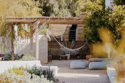 a patio with a hammock and a house at VILLA FLAKA Boutique Hôtel Wellness in Cargèse